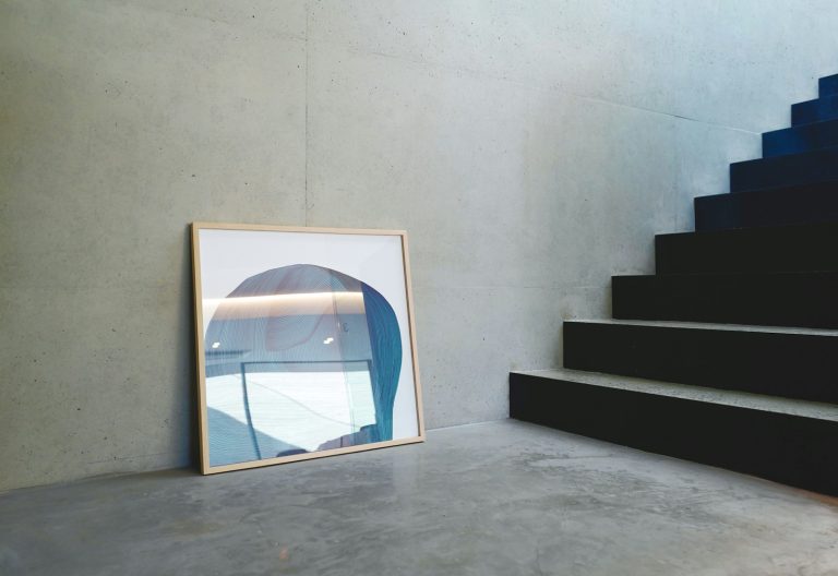 a picture frame sitting on the ground next to a stair case