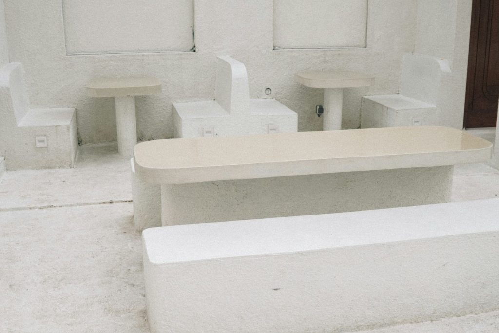 a white bench and two tables in a room