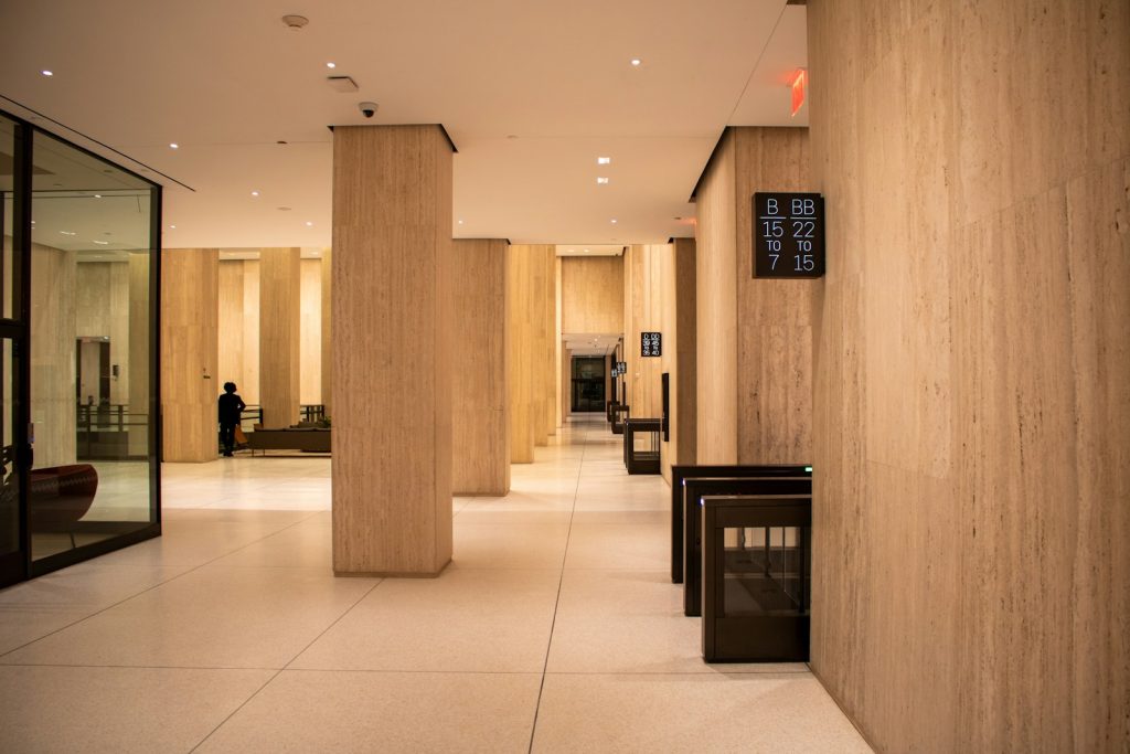 A modern lobby with pillars and a security gate.