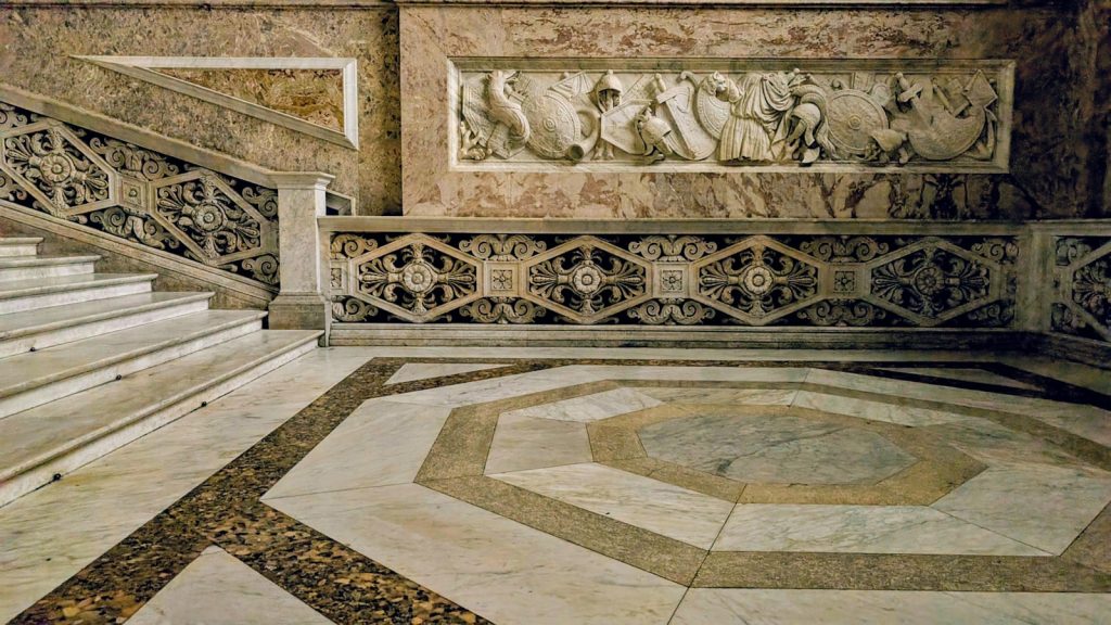 Marble staircase and ornate wall relief in grand building
